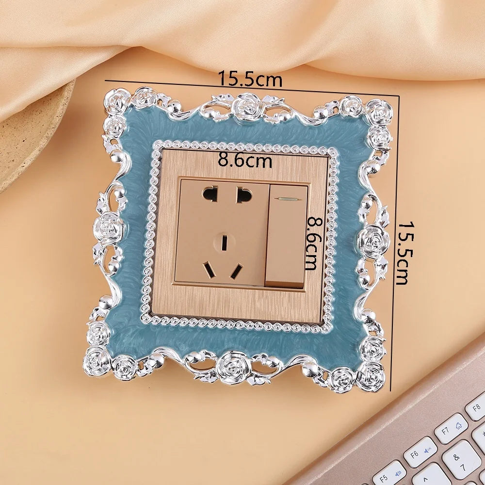 A rectangular switch cover frame with a teal border and silver decorative elements, shown against a light background.