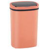 A modern, round, peach-colored automatic touchless trash can with a black lid.