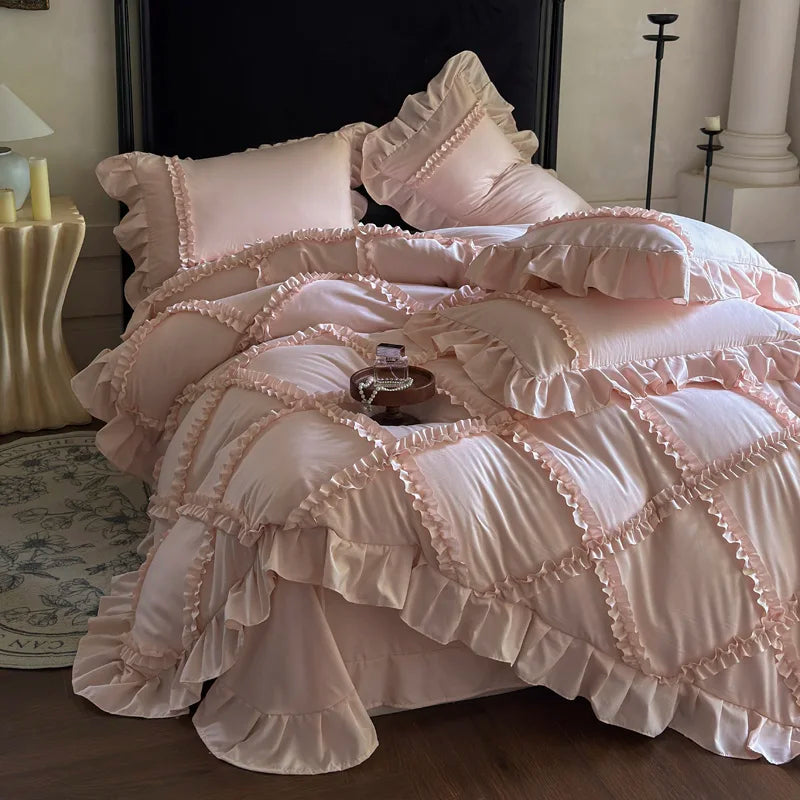 A pink ruffled duvet cover set with matching pillowcases and a decorative throw on a bed.