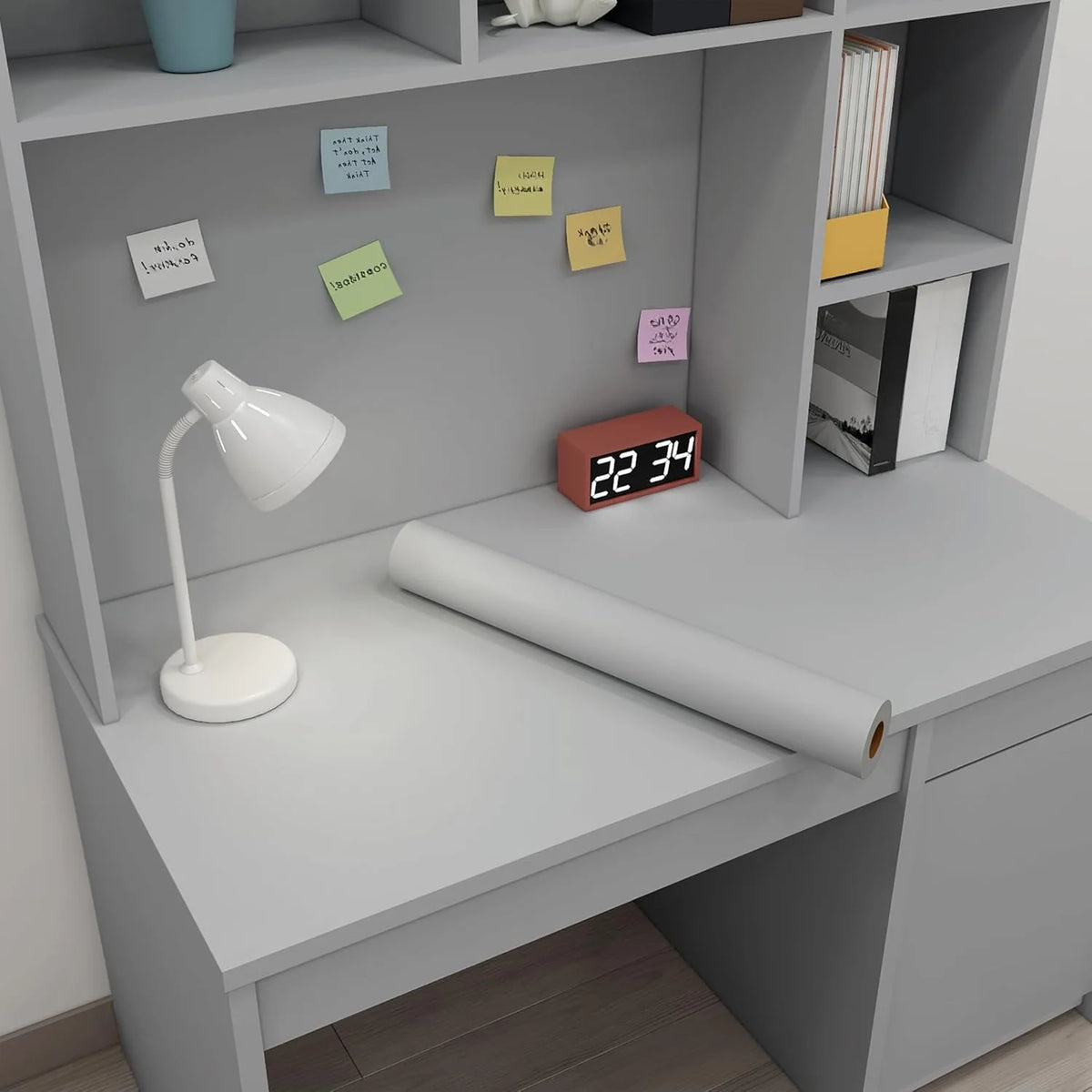 A roll of self-adhesive peel-and-stick wallpaper displayed on a light gray shelf with small sticky notes.