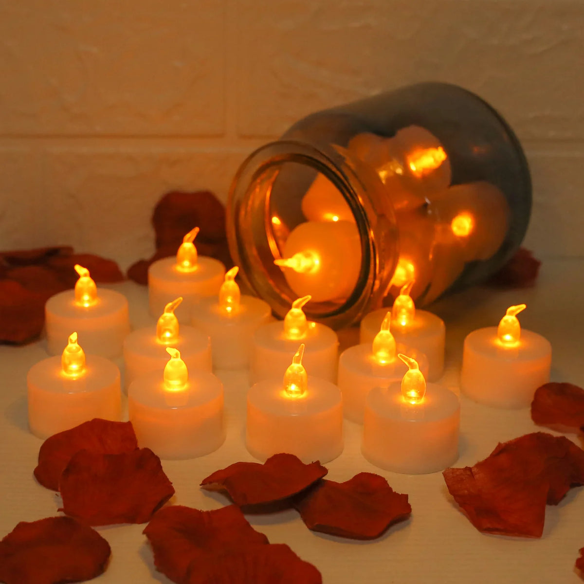 A collection of glowing LED tea lights in a glass jar surrounded by reddish-brown leaves.