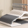 A display of five anti-slip heavy-duty plastic hangers with rotating hooks arranged on a light wooden surface.