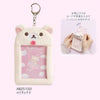A white Rilakkuma plush ID card holder and keychain with a pink frame and a small card inside.