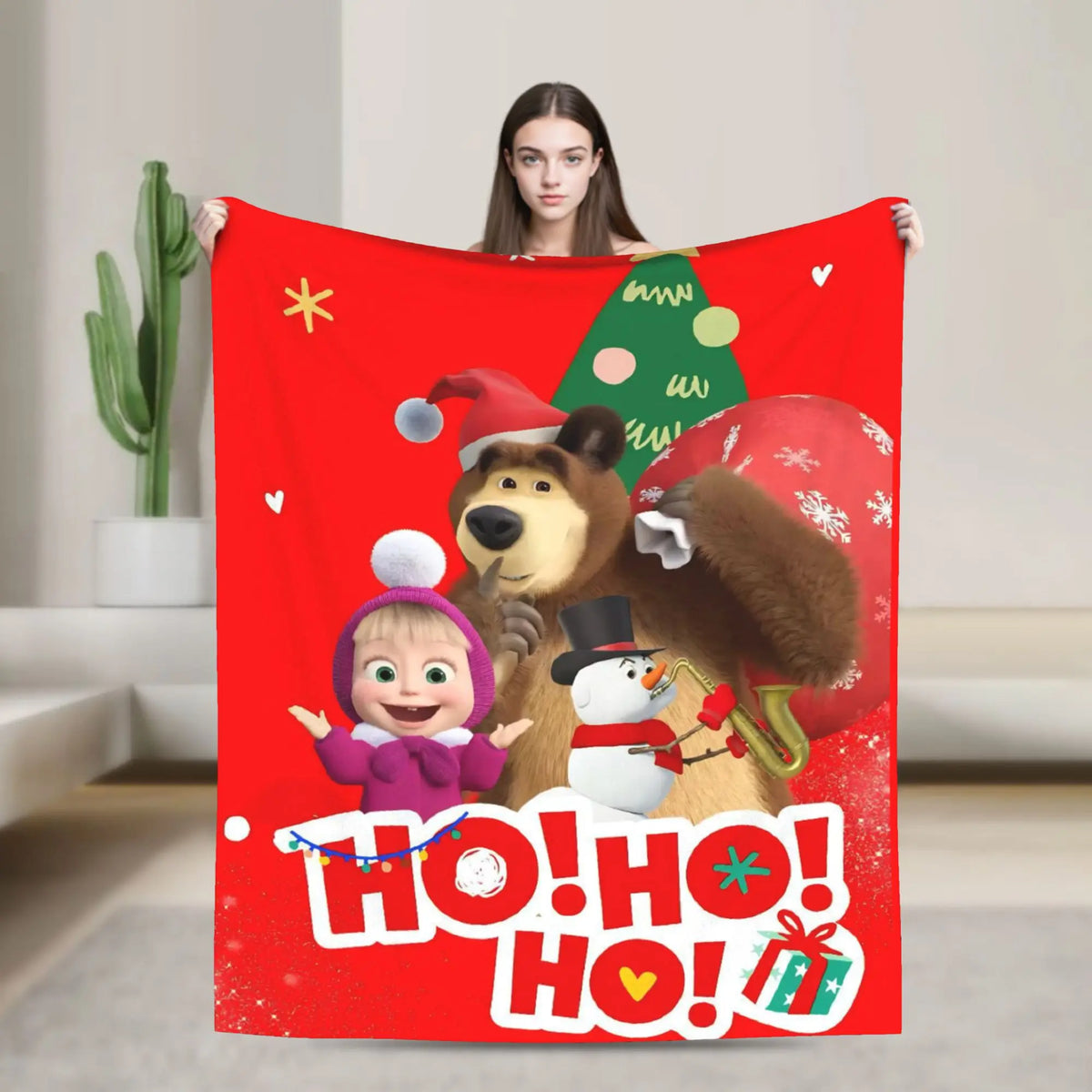 A red flannel throw blanket featuring a cartoon design of Masha and Bear.