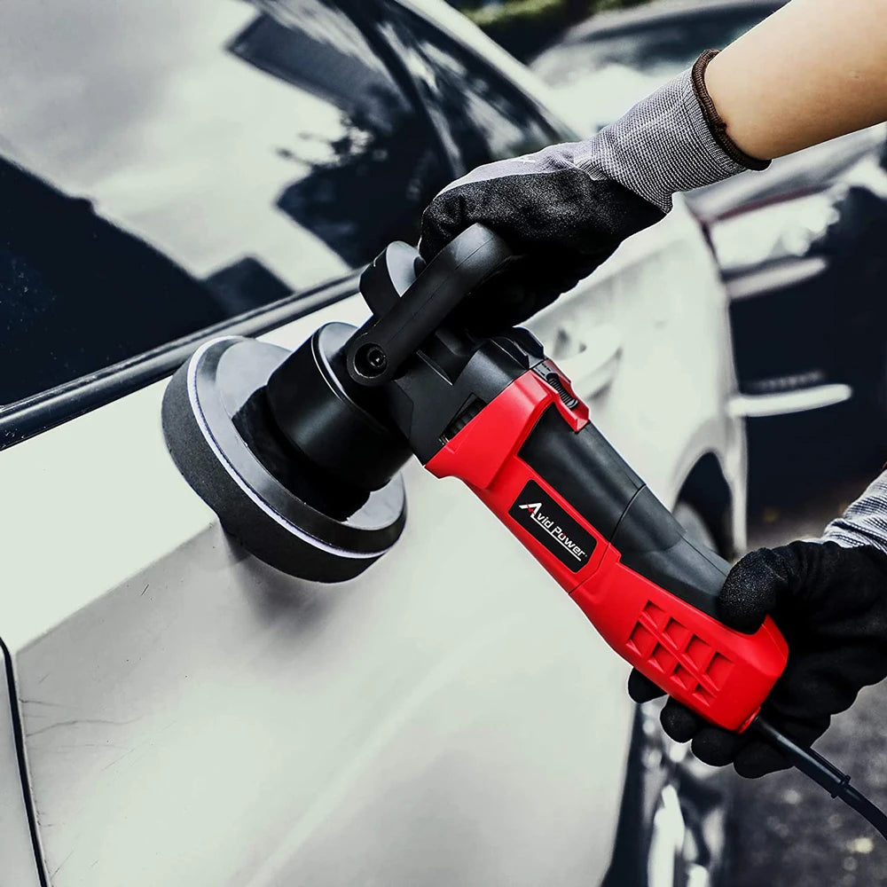 A hand wearing a glove is using a red and black car polishing tool on a white car surface.