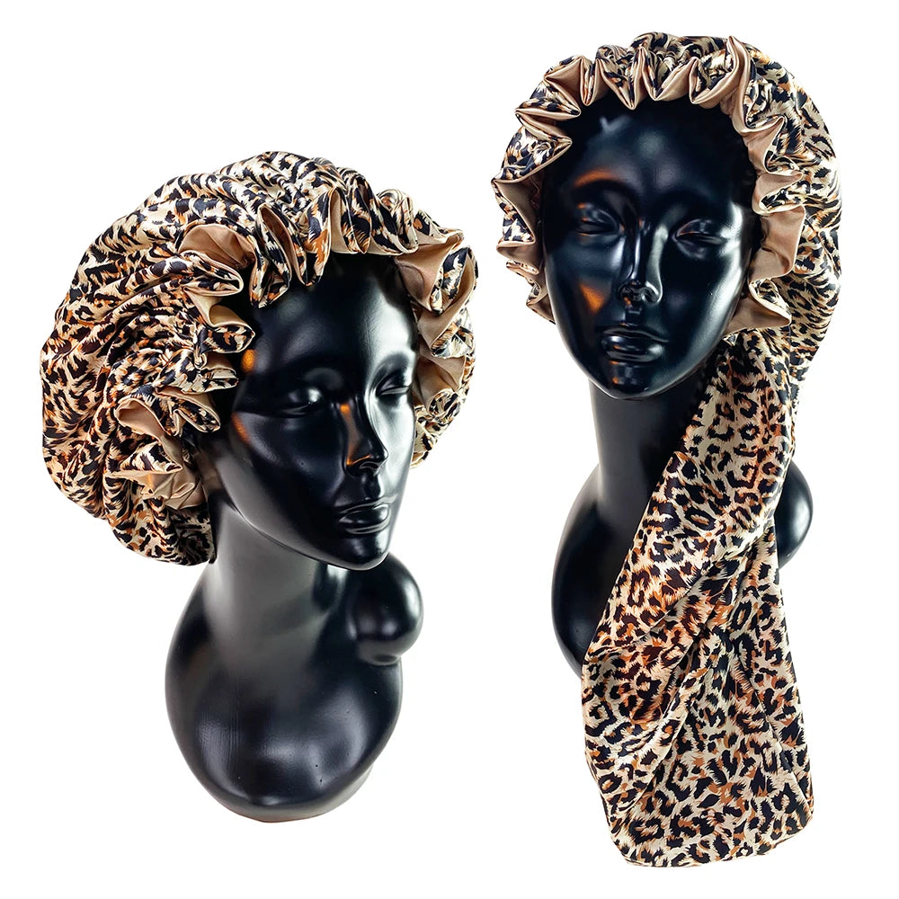 A black mannequin displays a double-layer satin hair bonnet with an adjustable band, featuring a leopard print fabric.