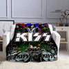 A black and white graphic print of the Kiss band on a flannel throw blanket displayed on a white sofa.