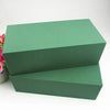 A square block of green floral foam used for flower arrangements.
