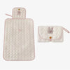 A light pink quilted foldable portable diaper changing pad with a rabbit design.