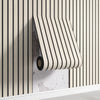 Roll of beige and white striped self-adhesive wall panels mounted on a light gray wall.