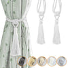 A set of two white tassel curtain tiebacks with twisted rope handles shown against a light green fabric background.