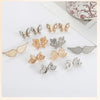 A collection of silver and gold no-sew adjustable waist tightener buttons shaped like butterflies and moons.
