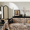Beige Sofa mit schwarzem floralem Stickbezug in einem hellen Raum