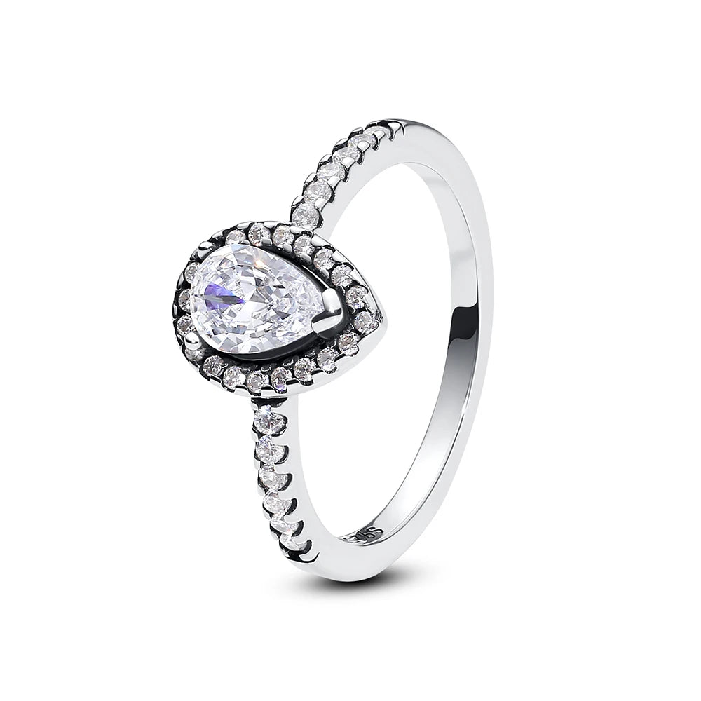 A sterling silver heart ring featuring a brilliant-cut diamond surrounded by pave cubic zirconia stones.