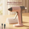 A pink glue gun is shown on a wooden surface with glue sticks and a USB cable nearby.