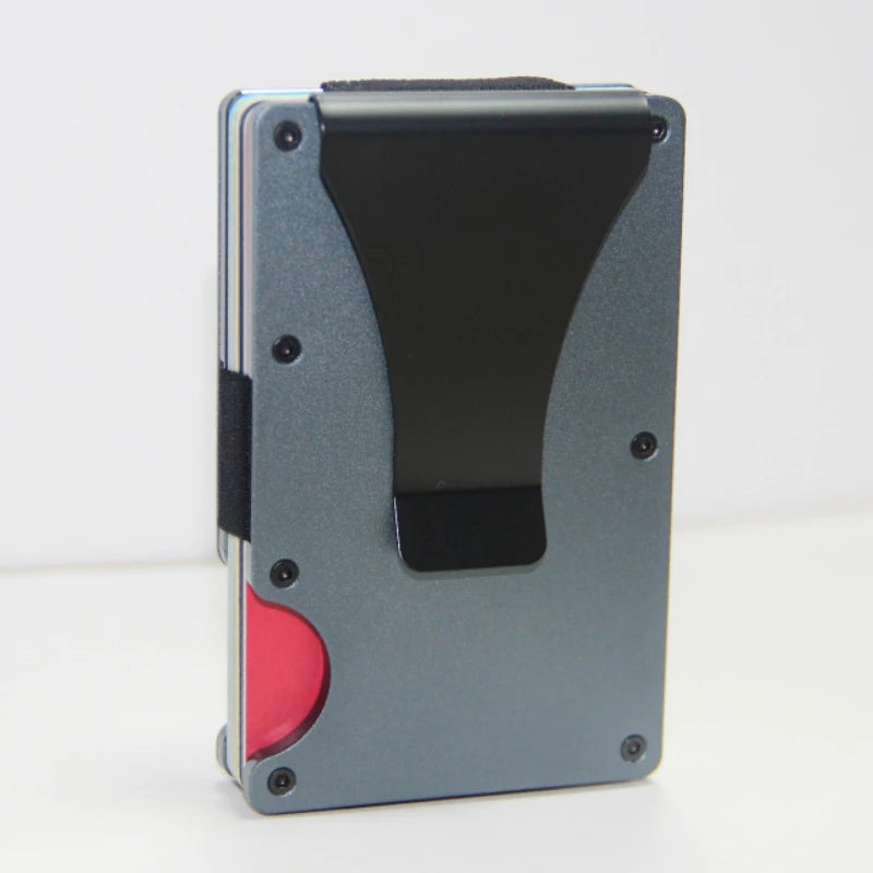 A slim gray aluminum wallet with a black RFID-blocking card slot and a red money clip visible.