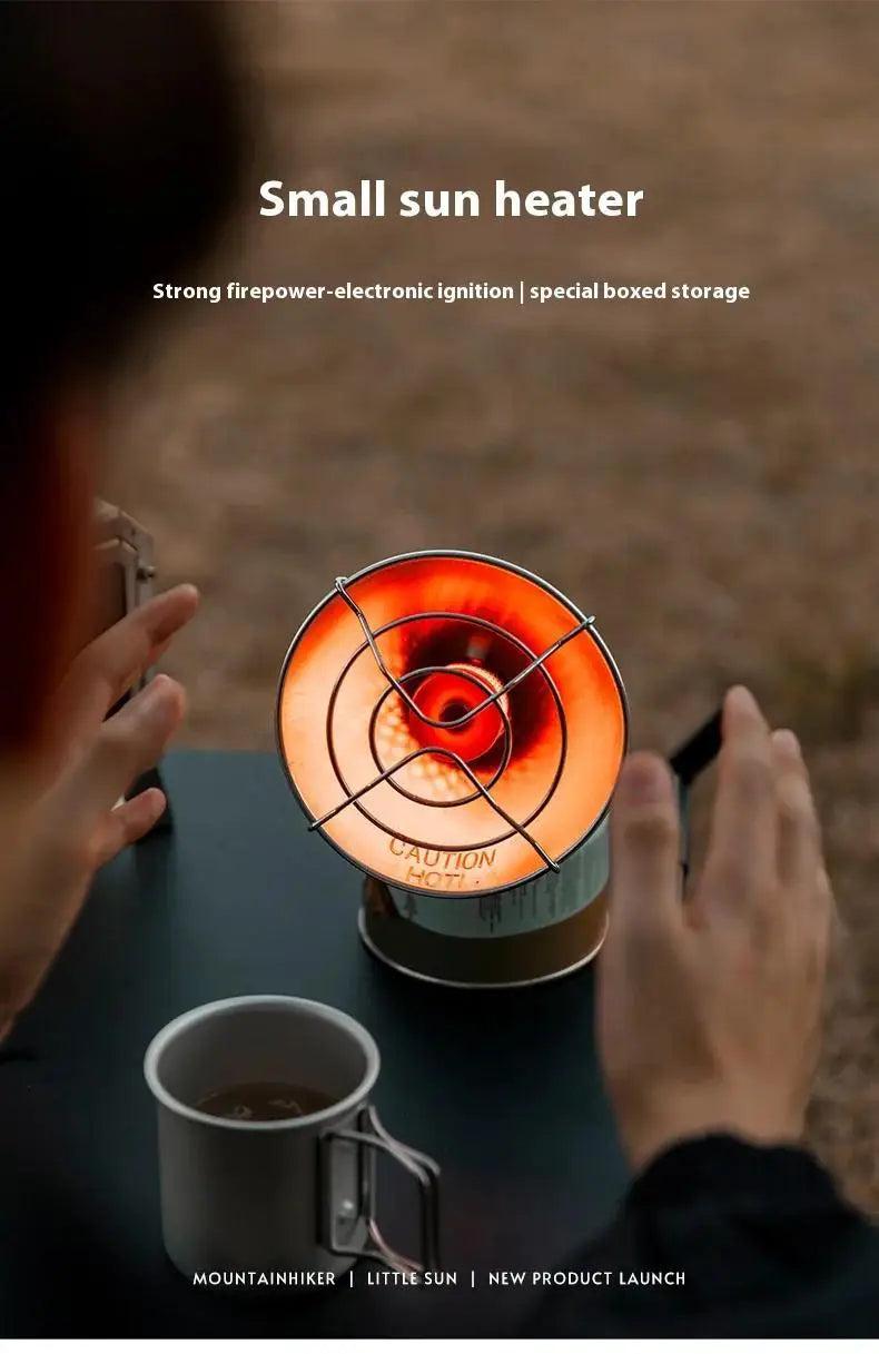 A hand holds a small sun heater with an ignition mechanism, set against a blurred outdoor background.