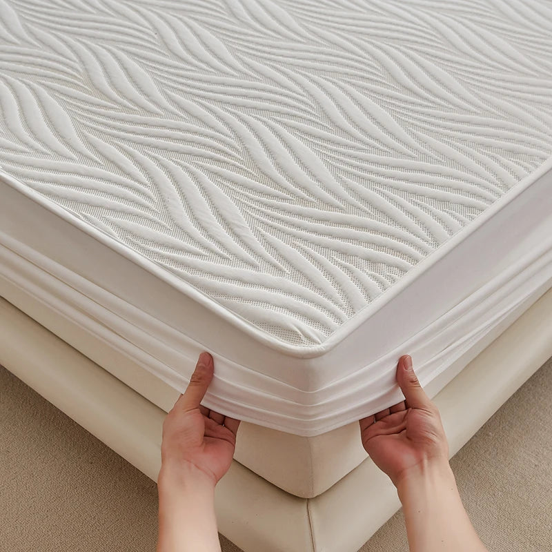 Hands lifting a white floral waterproof fitted mattress protector with a textured surface.