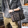 Eine Person hält eine braune Vintage-Ledertasche für Laptops, gepflegt mit einer grauen Jeansjacke und Khakihosen.