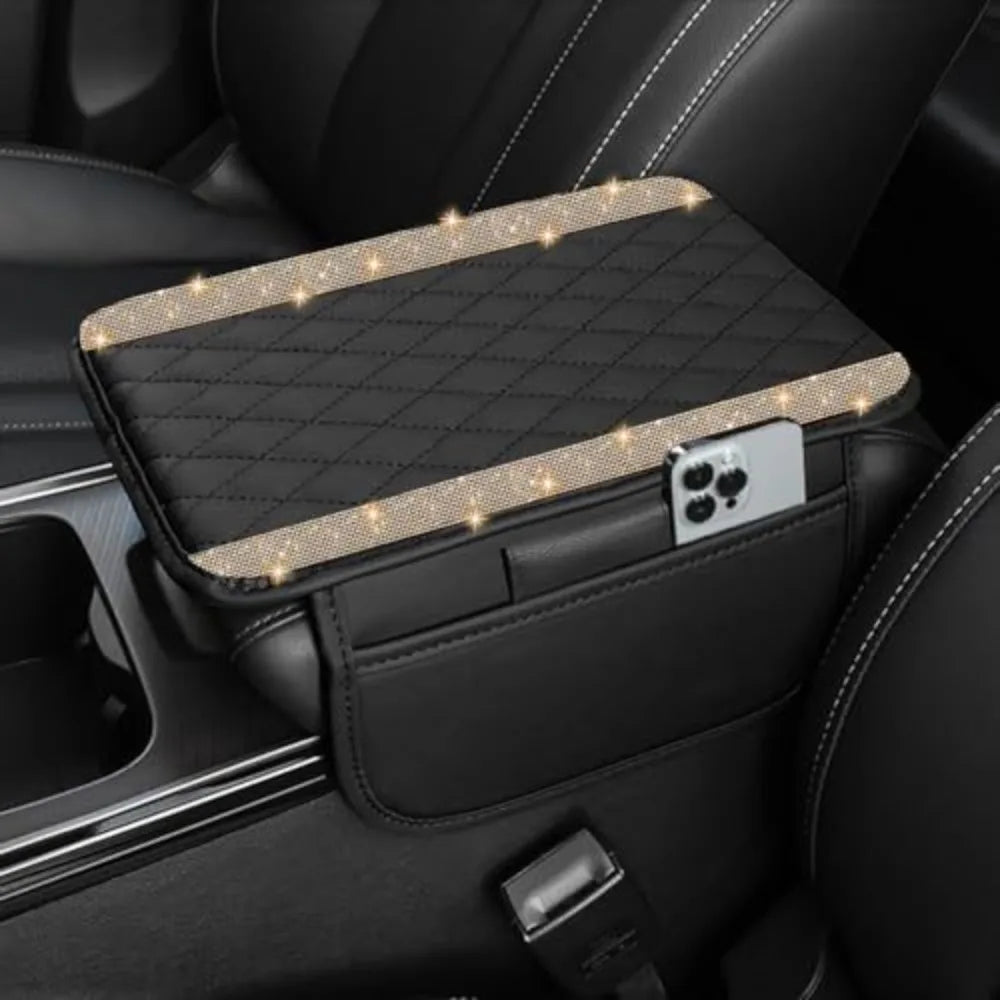 A black diamond quilted car armrest cover with storage featuring gold stitching and a smartphone slot.