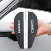A hand holds a black carbon fiber rearview mirror rain guard with the 'ceed' logo, showing its texture and design.