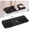 A black silicone faucet splash mat is shown mounted on a white surface, demonstrating its use in the kitchen or bathroom.