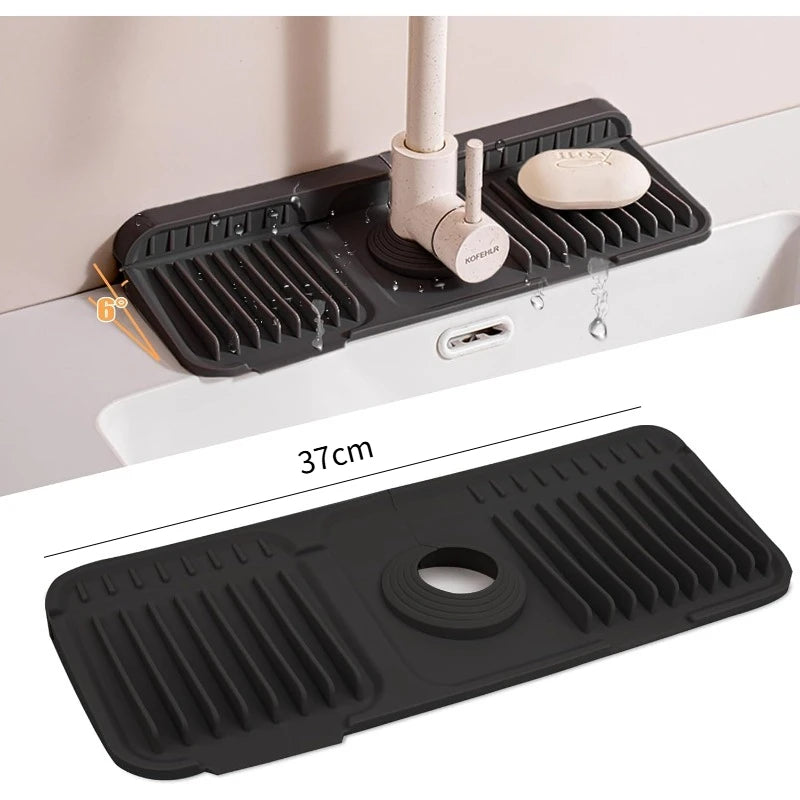 A black silicone faucet splash mat is shown mounted on a white surface, demonstrating its use in the kitchen or bathroom.