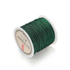 A spool of dark green 0.8mm nylon macramé cord for jewelry making with a white label.