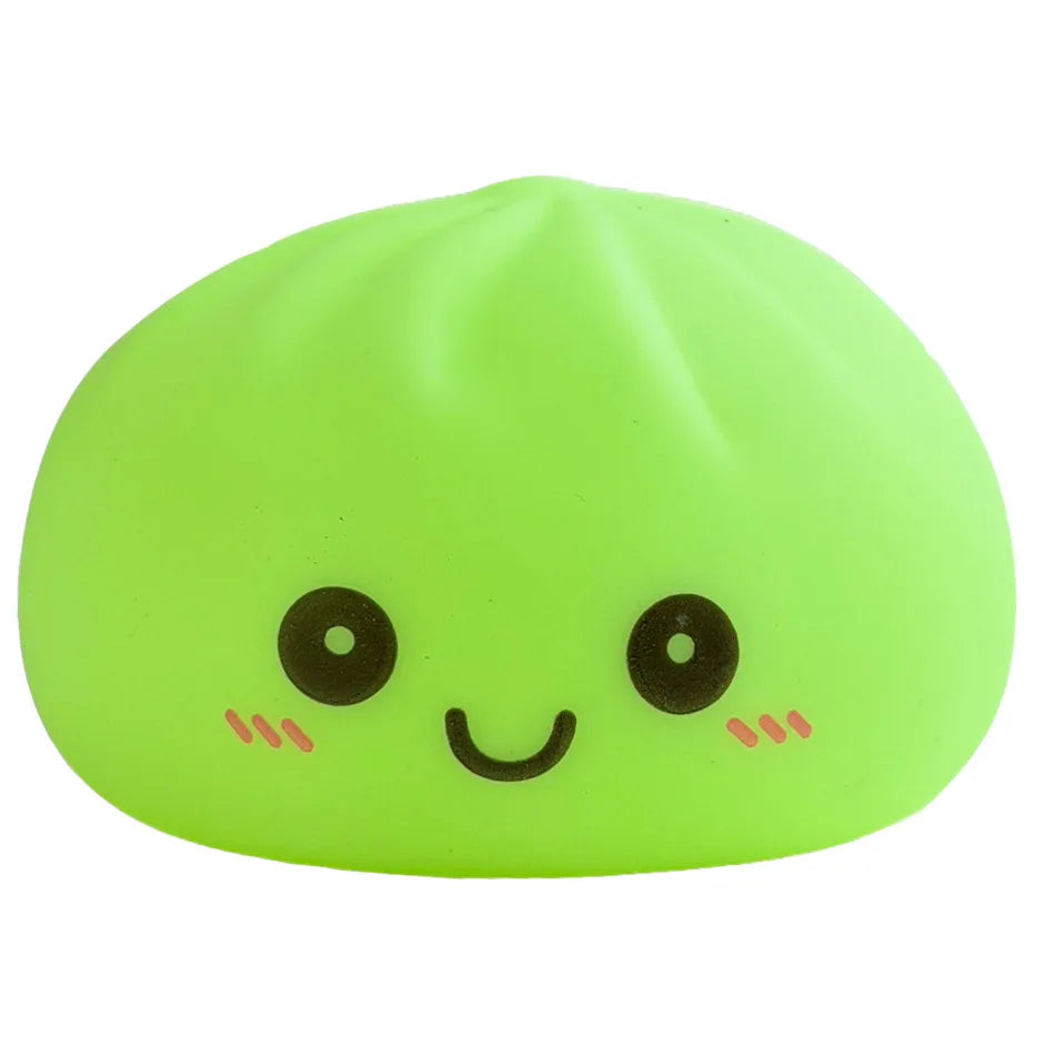 Juguete suave verde lima con forma de dumpling sonriente y ojos negros y mejillas rosadas.