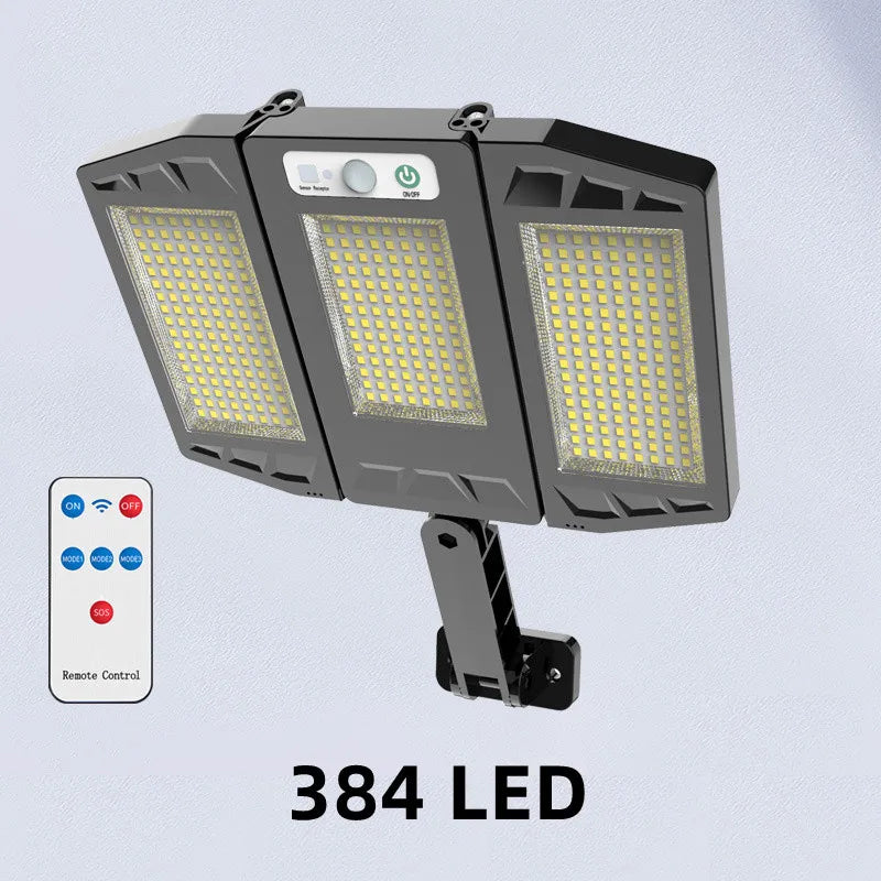 A black outdoor wall light fixture with three LED panels and a remote control is shown against a light gray background.