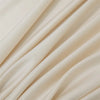 Close-up of flowing, light beige bamboo fabric draped in soft folds.