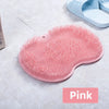 A pink suction cup foot massage mat with exfoliating bristles is shown on a light surface.