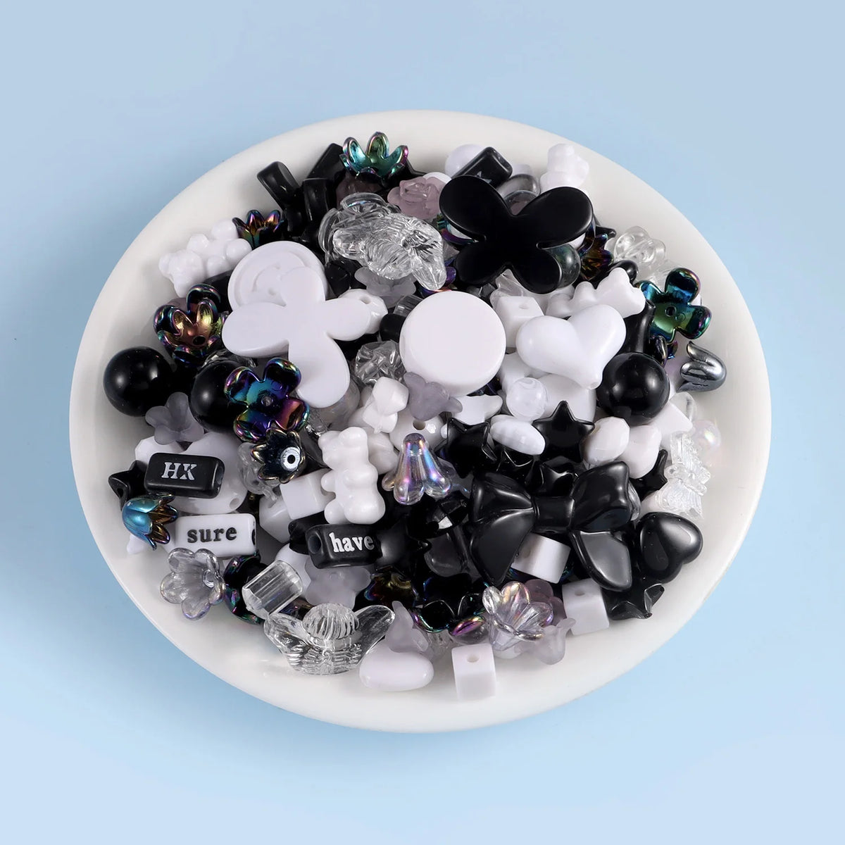 A collection of black, white, and iridescent acrylic beads for DIY jewelry making.