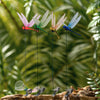 A collection of lifelike dragonfly garden clips with insect repellent designs hanging from a branch.