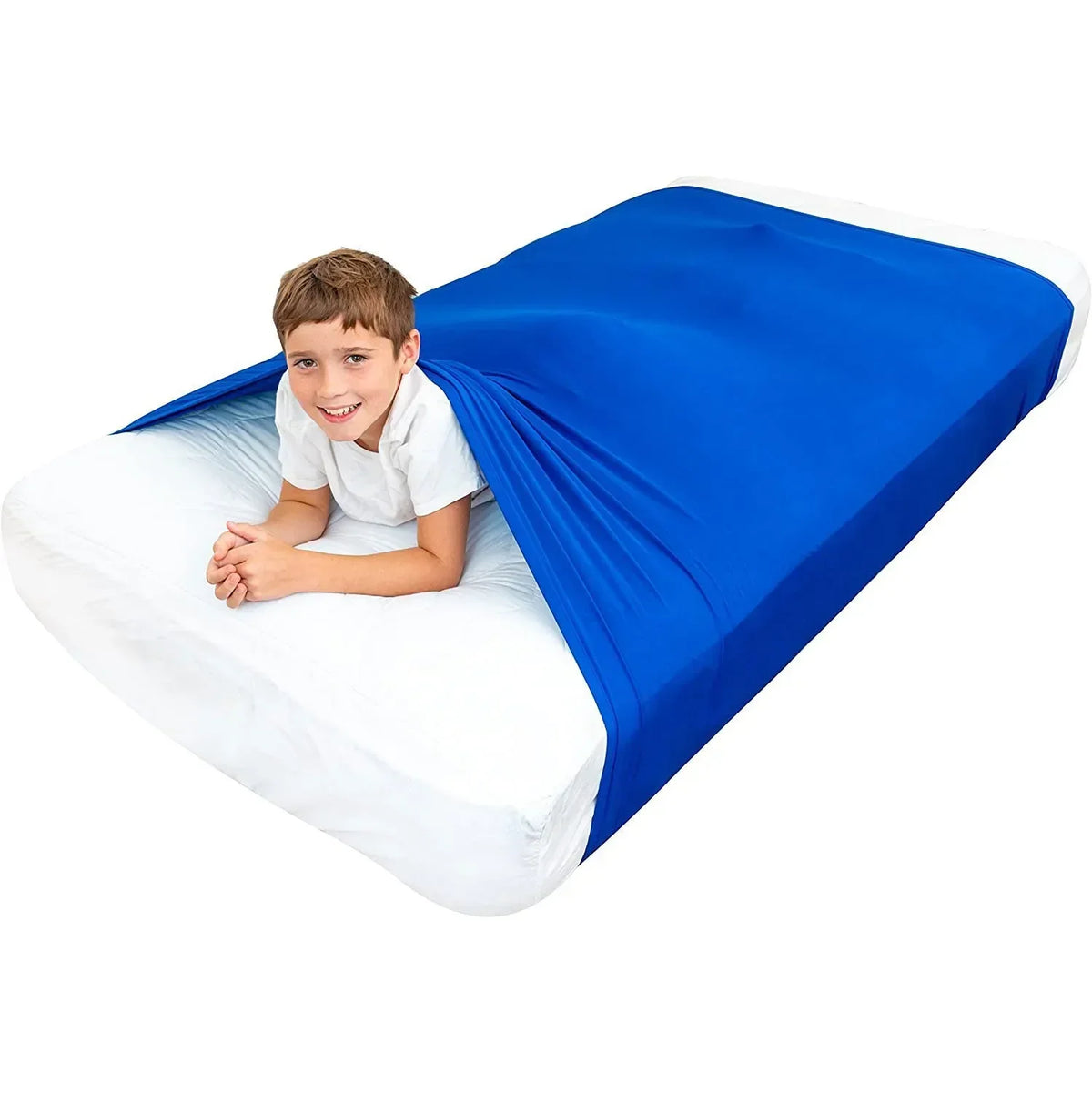 A smiling young boy lying on a white bed sheet with a bright blue breathable stretchy sensory sheet draped over him.