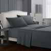 A bedroom featuring a gray upholstered headboard and bedding set with a matching gray duvet and pillows.