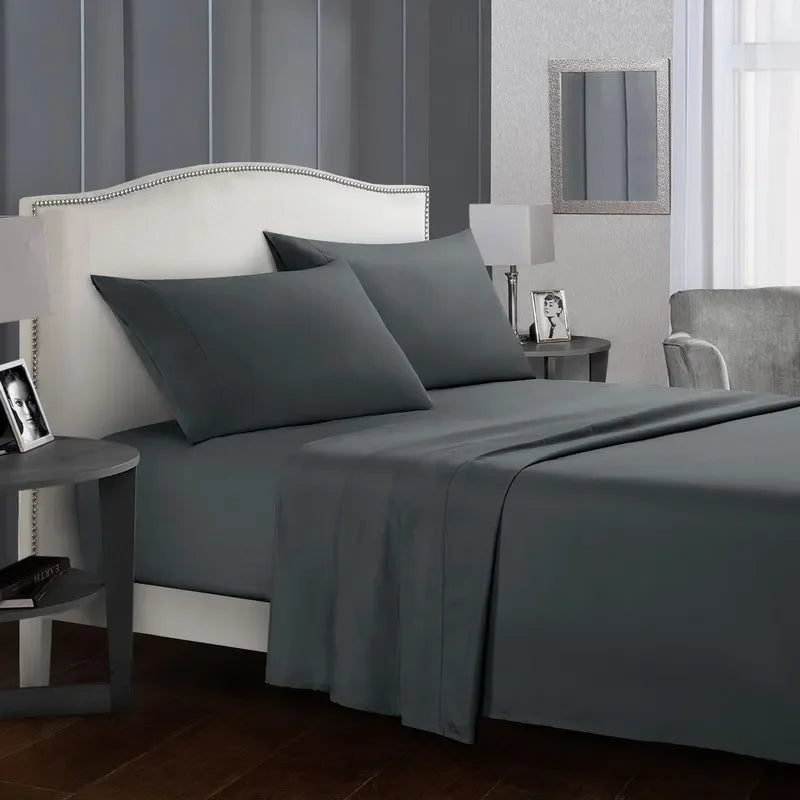 A bedroom featuring a gray upholstered headboard and bedding set with a matching gray duvet and pillows.
