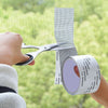 A hand is applying a self-adhesive mesh repair patch to a window screen or similar surface.