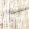 A roll of retro wood grain self-adhesive wallpaper lying on a light wooden floor.
