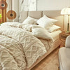 A luxurious beige velvet duvet cover and blanket with a diamond quilted pattern on a bed.