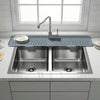 A stainless steel faucet mat with a modern kitchen sink and faucet set on a white countertop.