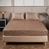 A bed dressed with luxury satin leopard print bedding set featuring brown and black animal print.