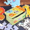 A green storage box of wooden animal puzzles featuring forest animals like a lion, zebra, and giraffe.