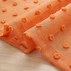 Orange sheer curtains featuring pom pom details and a 3D jacquard rod pocket.