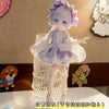 A white and lavender BJD doll wearing a frilly dress outfit with a lace collar and white stockings.