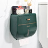 Porta papel higiénico de pared verde oscuro con acento dorado, sosteniendo papel y objetos decorativos.