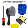A six-piece car cleaning set including a black brush, a blue scrubbing brush, a yellow towel, and two yellow pads.
