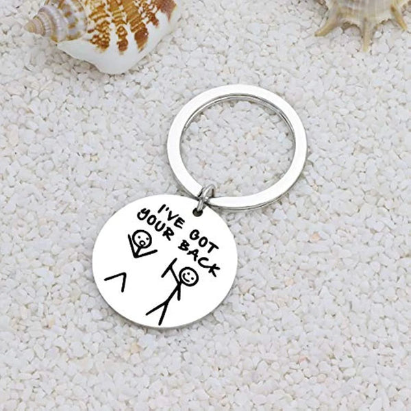 A silver stainless steel keychain with the text I've got your back engraved on a circular tag, resting on a white textured su