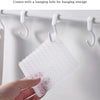 Une main tient un kit de tampons et brosses à crevasses en silicone transparent avec trou de suspension, prêt pour le rangeme