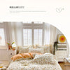 A light floral patterned duvet cover set displayed on a bed with white window blinds and natural light.